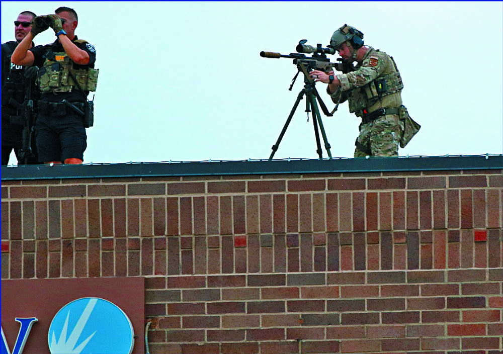Law enforcers check rooftops as spectators at a July 4 parade take cover. AFP, REUTERS