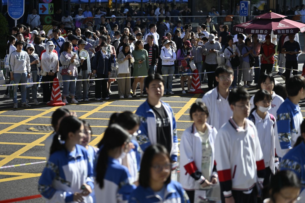 Parents (Back) wait outside a shcool as students line up to enter a school on the first day of China's National College Entrance Examination (NCEE) known as "gaokao", in Beijing on June 7, 2026.  (AFP)