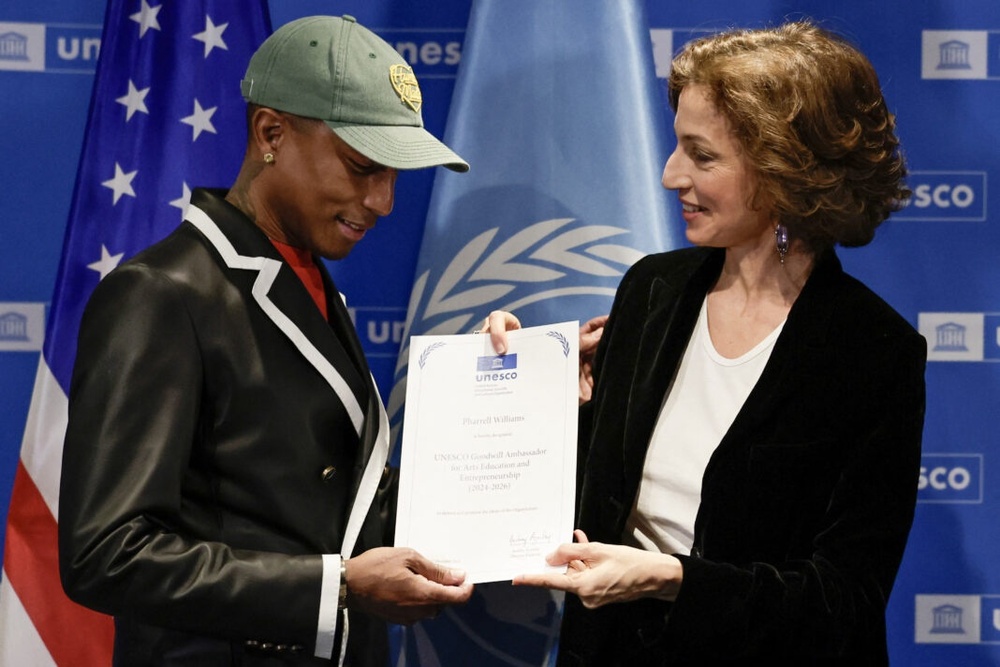 US rapper, producer and fashion designer Pharrell Williams (L) looks at his diploma received by UNESCO Director-General Audrey Azoulay as UNESCO Goodwill Ambassador for Arts, Education and Entrepreneurship, at the UNESCO headquarters, in Paris on December 17, 2024. (Photo by STEPHANE DE SAKUTIN / AFP) US rapper, producer and fashion designer Pharrell Williams (L) looks at his diploma received by UNESCO Director-General Audrey Azoulay as UNESCO Goodwill Ambassador for Arts, Education and Entrepreneurship, at the UNESCO headquarters, in Paris on December 17, 2024. (Photo by STEPHANE DE SAKUTIN / AFP)