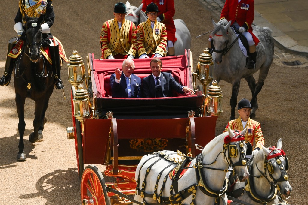 Britain's King Charles and French President Emmanuel Macron sit on a carriage as they arrive at Windsor Castle, in Windsor, Britain, July 8, 2025. (Reuters)