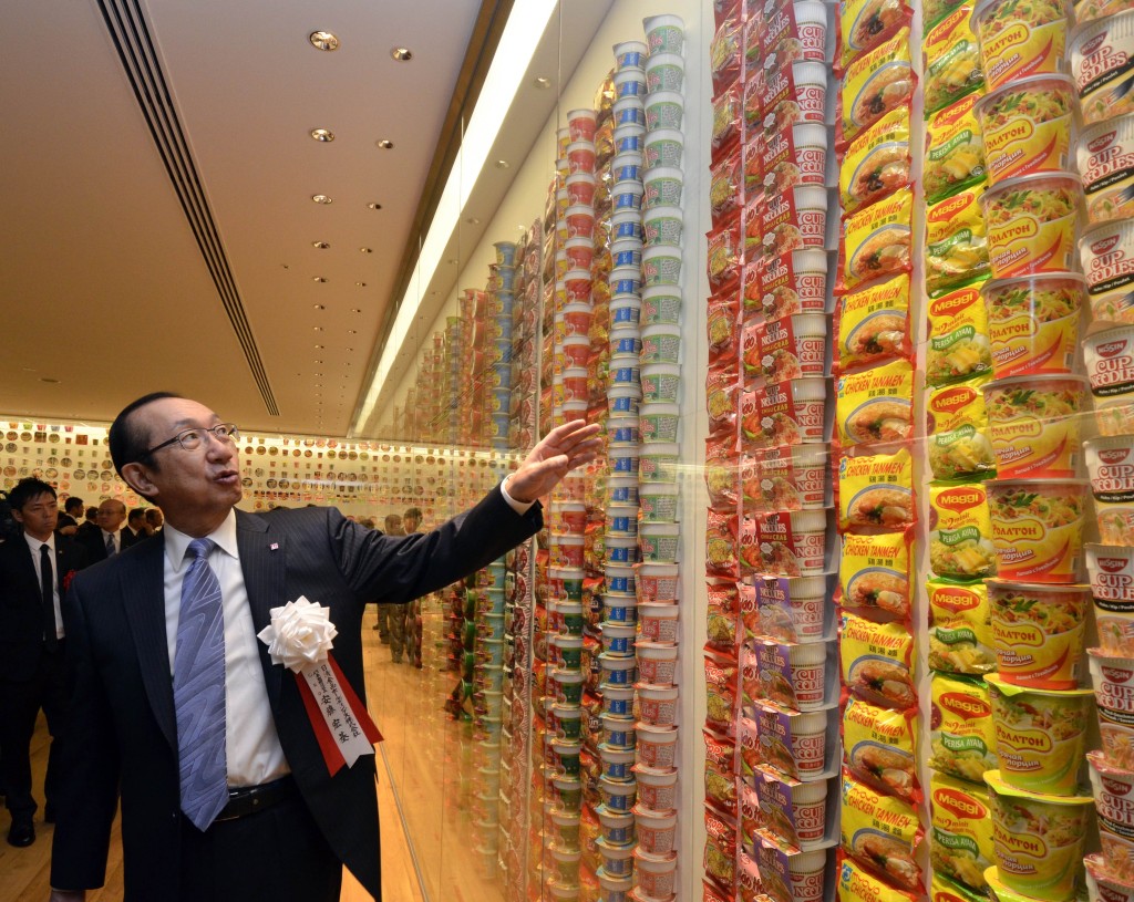 Nissin Foods Holdings president Koki Ando, a son of instant noodle inventor Momofuku Ando, looks at a display of instant noodle packages from various countries at the opening of a cup noodle museum in Yokohama, suburban Tokyo, on September 17, 2011. Japan's Nissin Foods opened a cup noodle museum on September 17 charting the history of the speedy snack where visitors even get the chance to create their own tasty version. About 500 adults and children queued up before the museum opened in the port city of Yo