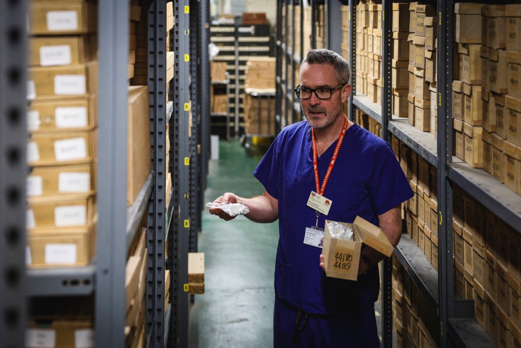 Photo by ADRIAN DENNIS / AFP  This photo taken on January 14, 2026 shows consultant gastroenterologist Kevin Monahan looking through samples in a storeroom at St Mark’s hospital at Northwick Park in Harrow, west London.