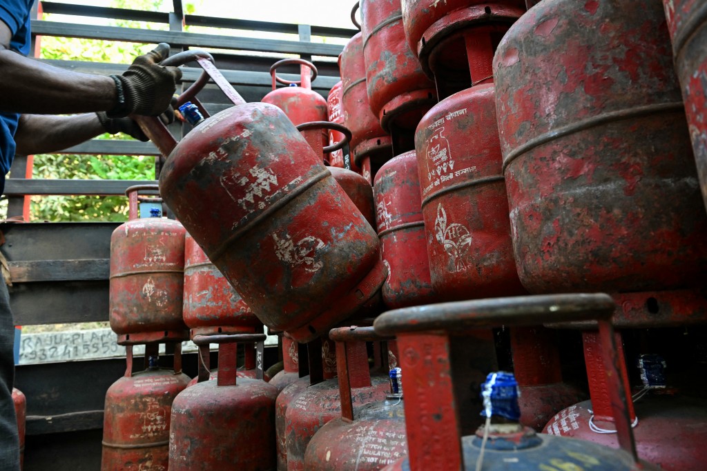 Photo by INDRANIL MUKHERJEE / AFP  A delivery staff unloads liquefied petroleum gas (LPG) cylinders from a truck at a distribution point in Mumbai on March 10, 2026.