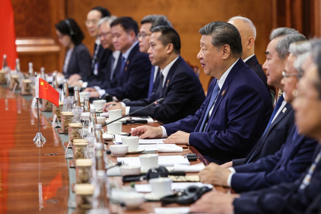 This handout photograph taken on September 12, 2026 and released by the Indian Press Information Bureau (PIB) shows China's President Xi Jinping (4R) alongside Foreign Minister Wang Yi (3R) speaking during a bilateral meeting with India's Prime Minister Narendra Modi (not pictured) on the sidelines of the 18th BRICS Summit at the Bharat Mandapam in New Delhi on September 12, 2026. (Photo by Handout / Indian Press Information Bureau (PIB) / AFP)