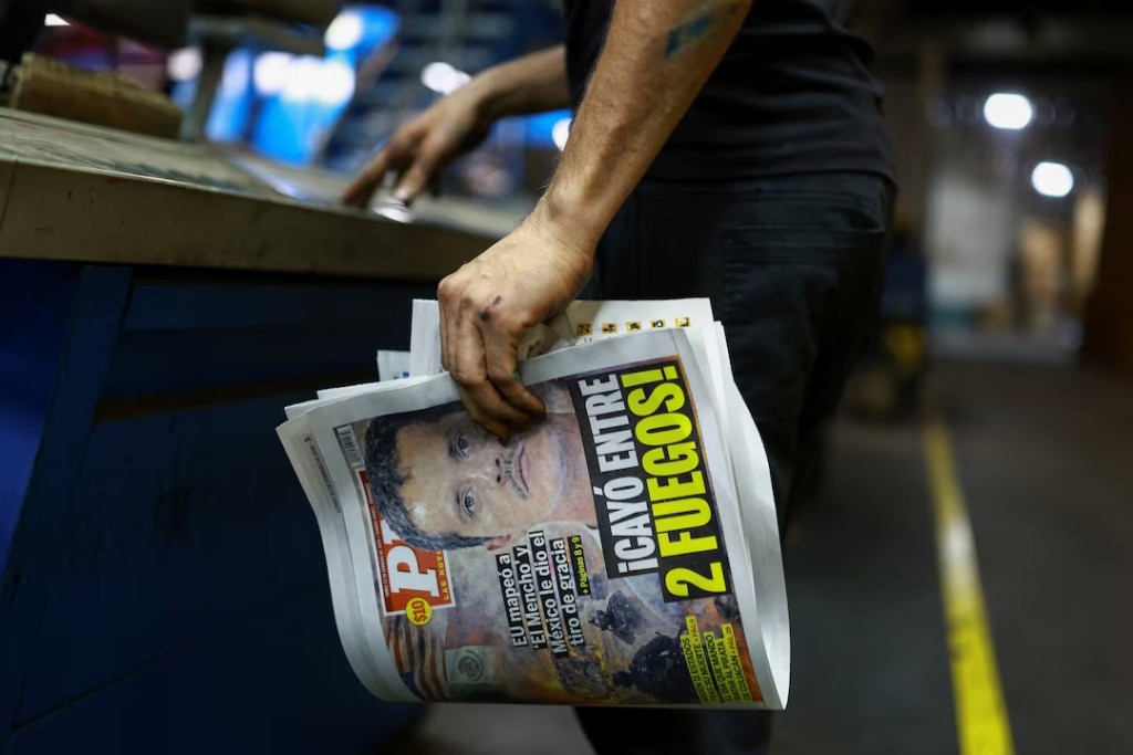 A printing worker holds a freshly printed copy of the newspaper PM bearing the headline "U.S. mapped ‘El Mencho’ and Mexico delivered the final blow, Caught between two fires," following the killing of drug lord Nemesio Oseguera, known as 'El Mencho,' in a military operation on Sunday, in Ciudad Juarez, Mexico, February 22, 2026. REUTERS/Jose Luis Gonzalez