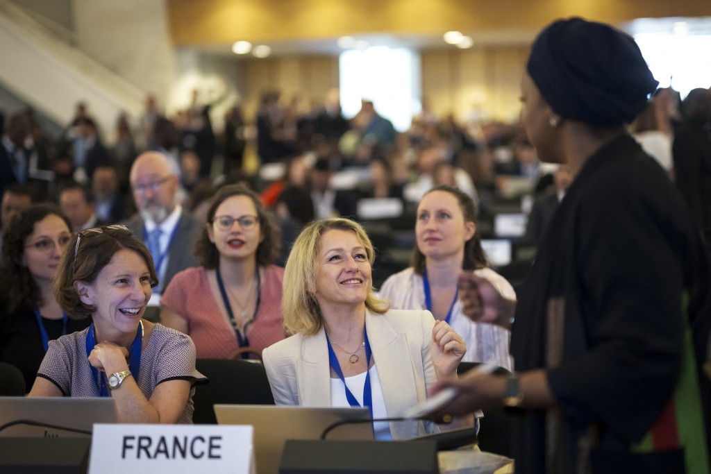 France's representative Barbara Pompili (C) reacts prior to the start of plastics treaty negotiations at the United Nations Offices in Geneva on August 5, 2025. (Photo by Fabrice COFFRINI / AFP)