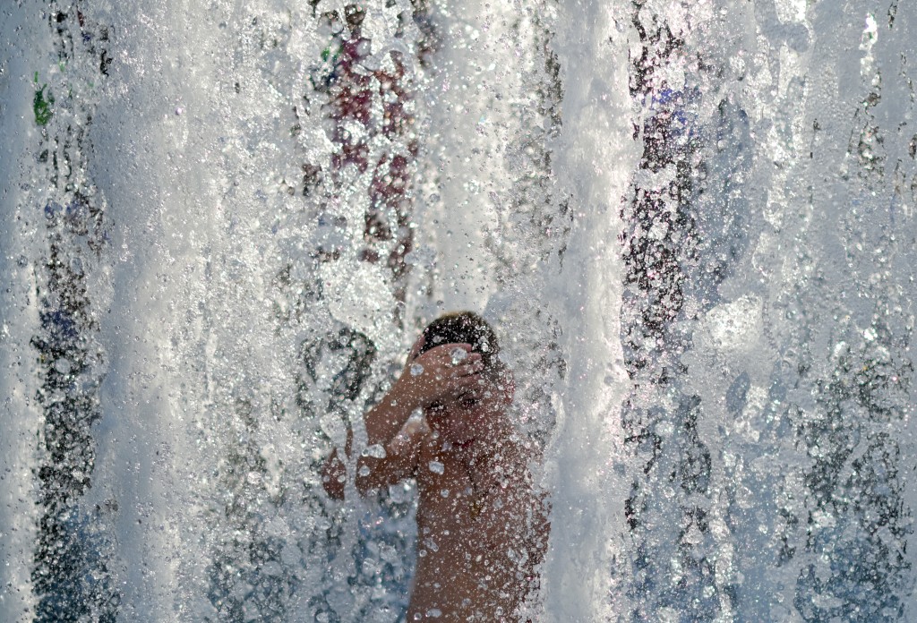 A child cools off in a public fountain. (AFP)