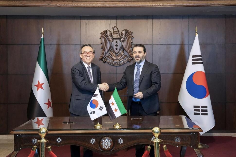 In this photo provided by South Korea Foreign Ministry, South Korean Foreign Minister Cho Tae-yul, left, shakes hands with Syrian Foreign Minister Asaad al-Shaibani after signing a joint statement on the establishment of diplomatic ties between the countries in Damascus, Syria, Thursday, April 10, 2025. (South Korea Foreign Ministry via AP)