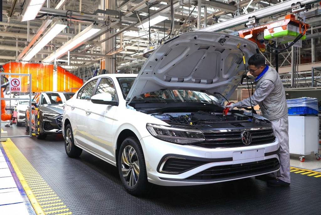 A worker assembles a vehicle on a production line at a FAW-Volkswagen factory in Qingdao, in China eastern Shandong province on January 27, 2026. (Photo by -STR / AFP)