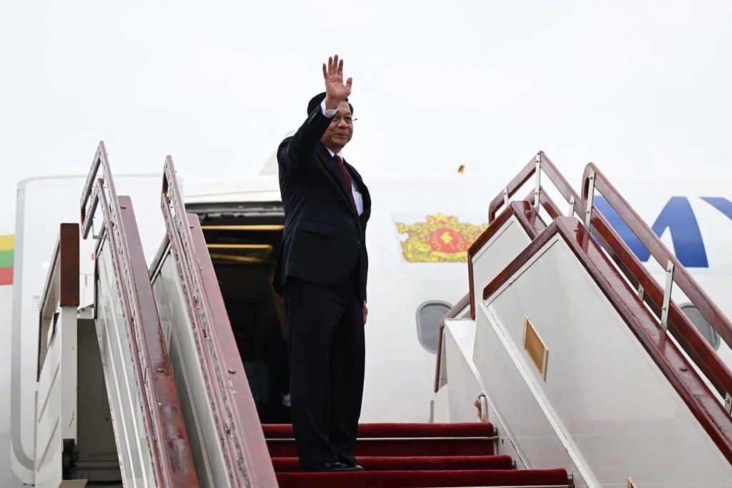 Myanmar's President Min Aung Hlaing waving as he boards a plane at Naypyidaw International Airport. (AFP)