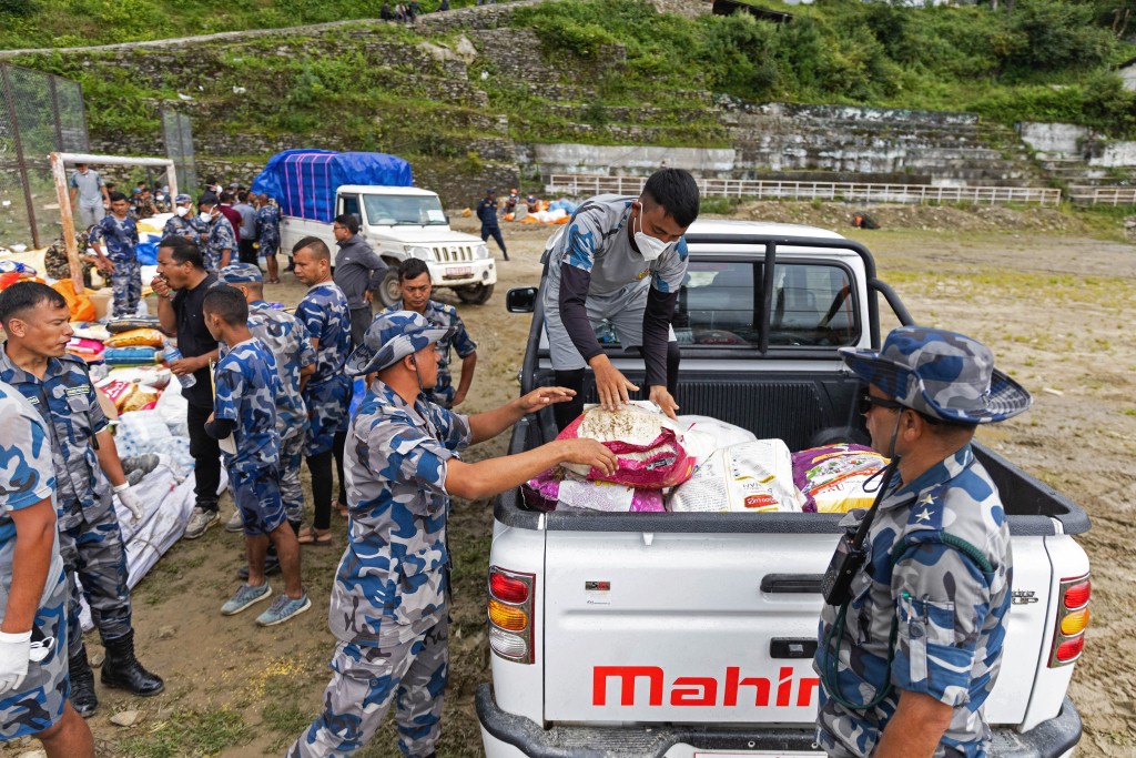 Photo by PRABIN RANABHAT / AFP  Nepal Armed Police Force (APF) personnel sort relief supplies for flood victims in Nepal's Rasuwa district on August 31, 2026.