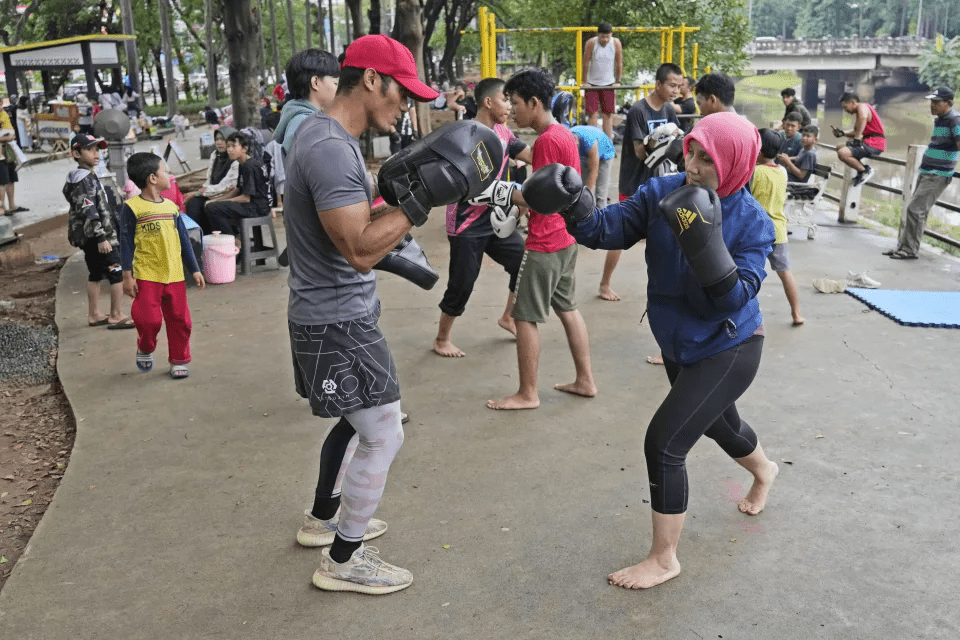 Rani Miranti, right, practices martial arts with Rizal Zulmi, a professional MMA fighter, at a public park in Jakarta, Indonesia, Sunday, July 7, 2024. (AP Photo/Achmad Ibrahim) Rani Miranti, right, practices martial arts with Rizal Zulmi, a professional MMA fighter, at a public park in Jakarta, Indonesia, Sunday, July 7, 2024. (AP Photo/Achmad Ibrahim)