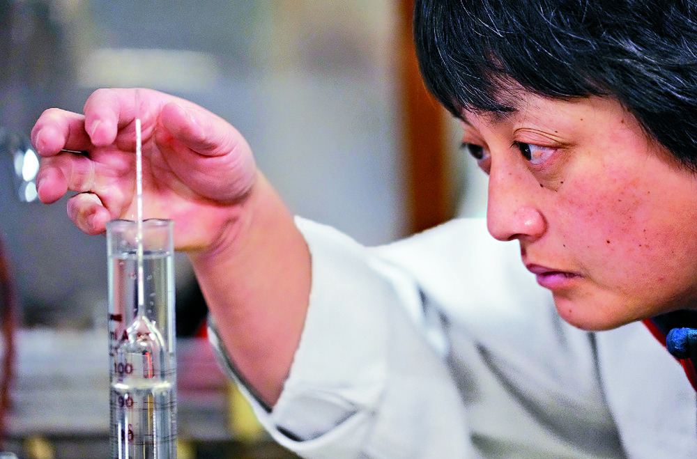 Mie Takahashi oversees her team and, inset, checks on a fermentation mash. ap Mie Takahashi oversees her team and, inset, checks on a fermentation mash. ap