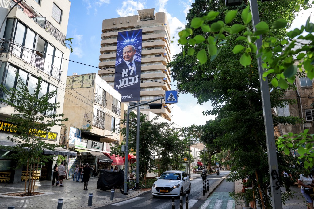 A giant electoral poster for Israeli Prime Minister Benjamin Netanyahu's Likud party with the slogan "no surrender" is displayed on the facade of a building in Tel Aviv on September 29, 2026 during campaigns ahead of the October 2026 legislative elections. (Photo by Jack GUEZ / AFP)