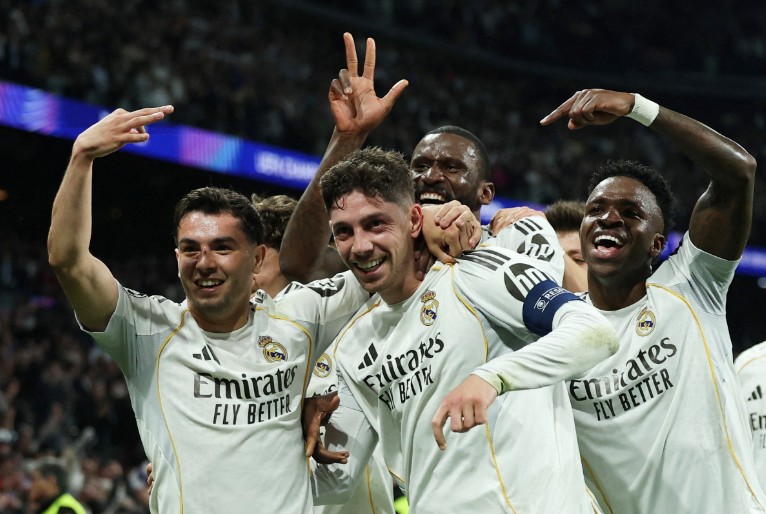 Hat-trick hero Federico Valverde, center, is mobbed by Real Madrid teammates. REUTERS