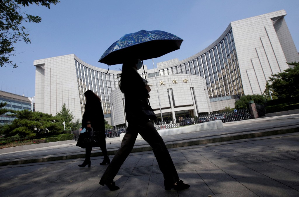 People walk past the headquarters of the People's Bank of China (PBOC), the central bank, in Beijing, China September 28, 2018. REUTERS