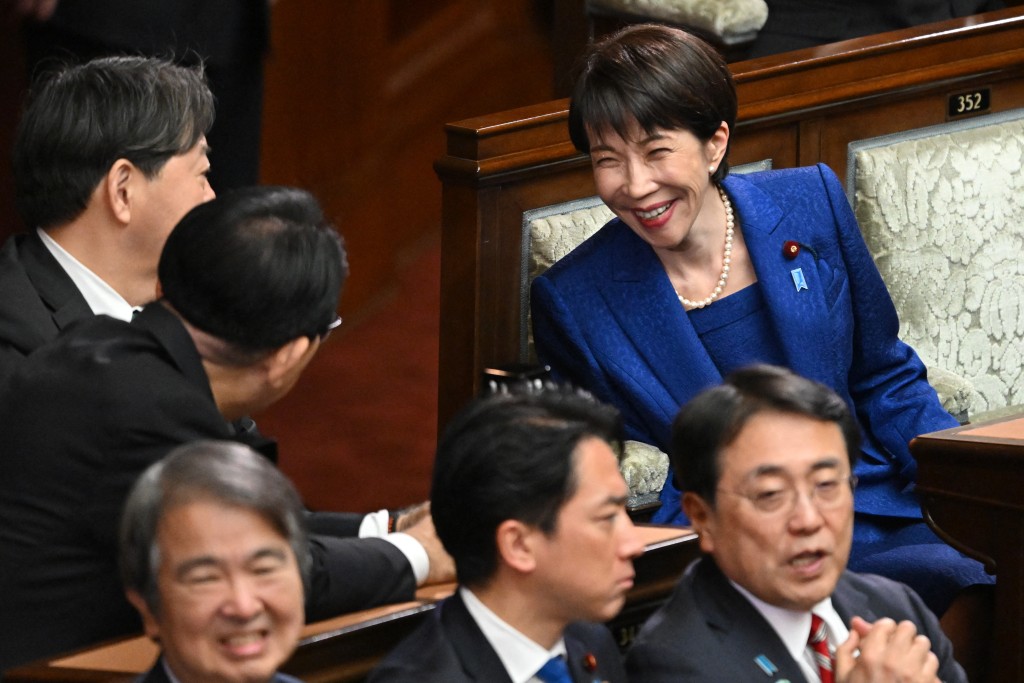 Japan's Prime Minister Sanae Takaichi (R) smiles and chats with cabinet members before a plenary session of the House of Representatives at the Diet in Tokyo on January 23, 2026.  Photo by KAZUHIRO NOGI / AFP