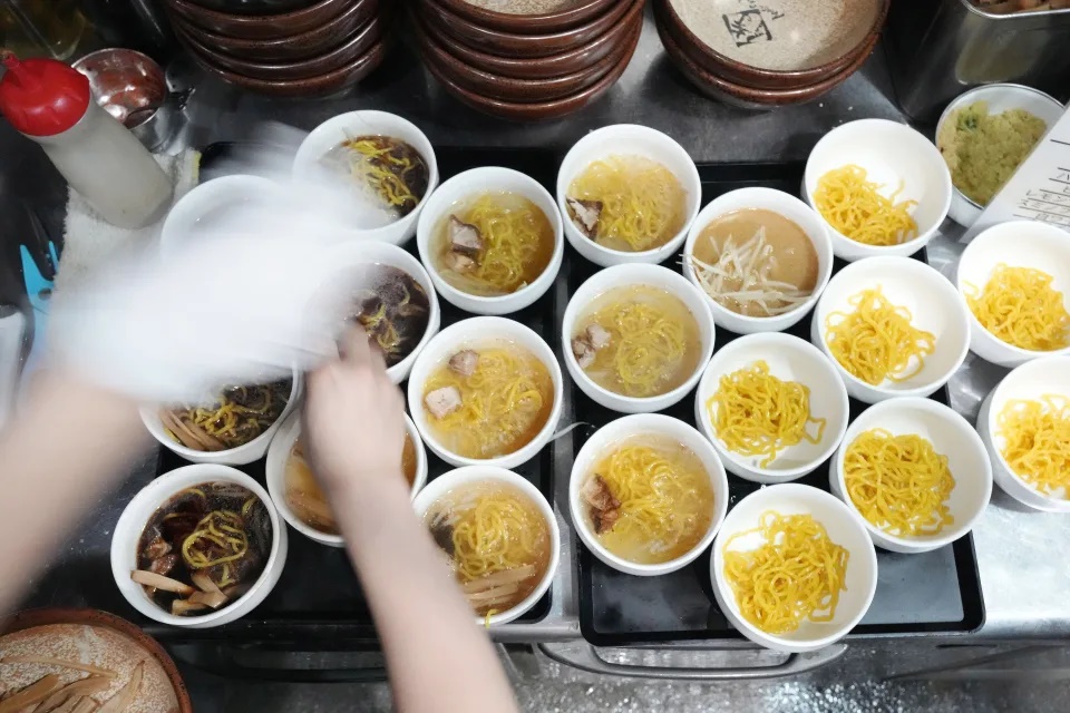 A staff member prepares small bowls of noodle for participants of Tokyo Ramen Tours at Shinbusakiya, a ramen shop which offers A staff member prepares small bowls of noodle for participants of Tokyo Ramen Tours at Shinbusakiya, a ramen shop which offers