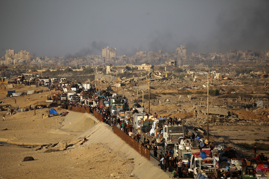 Displaced Palestinians move with their belongings southwards on a road in the Nuseirat refugee camp area in the central Gaza Strip on September 23, 2025, as Israel presses its ground offensive to capture Gaza City amidst the war against Hamas. (Photo by Eyad BABA / AFP)