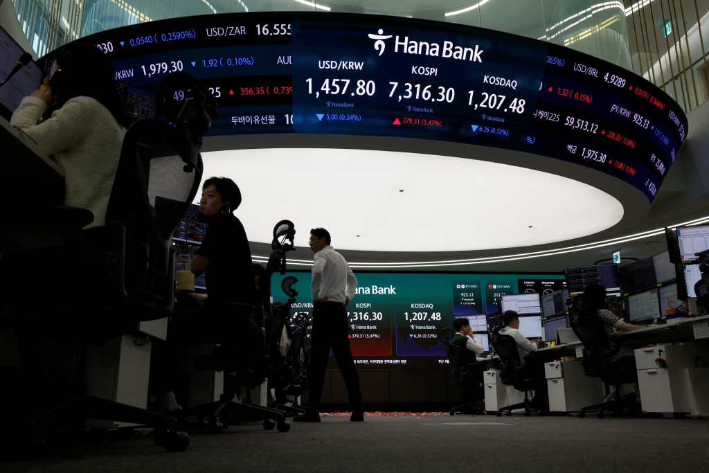 Currency dealers work as an electronic board displays the Korea Composite Stock Price Index (KOSPI), the exchange rate between the U.S. dollar and South Korean won and the Korea Securities Dealers Automated Quotations (KOSDAQ) at the dealing room of a bank, as the benchmark KOSPI index opened above the 7,000 mark in Seoul, South Korea, May 6, 2026. REUTERS