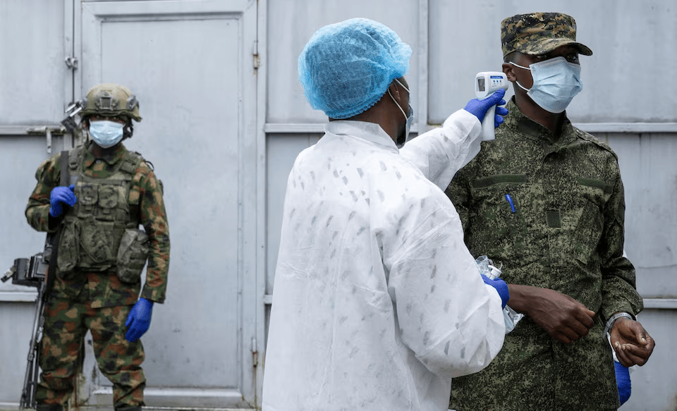 A health worker takes the temperature of an M23 rebel outside the laboratory where samples from suspected Ebola cases are examin