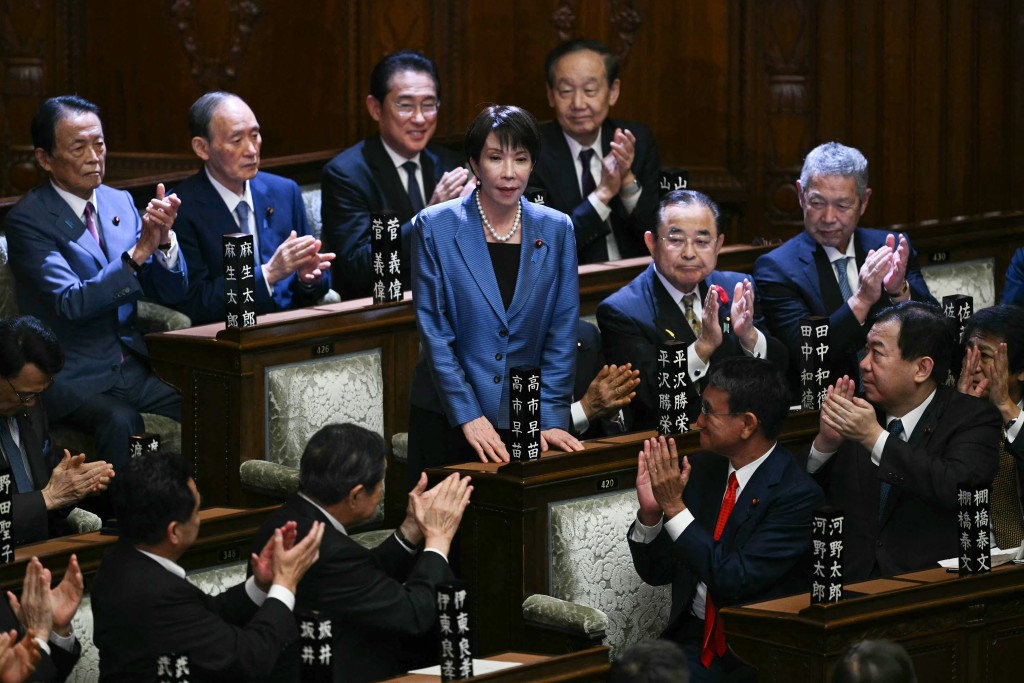 Liberal Democratic Party (LDP) President Sanae Takaichi stands up to acknowledge the applause after she was selected as Japan's new prime minister during an extraordinary session of the lower house of parliament in Tokyo on October 21, 2025. (AFP)