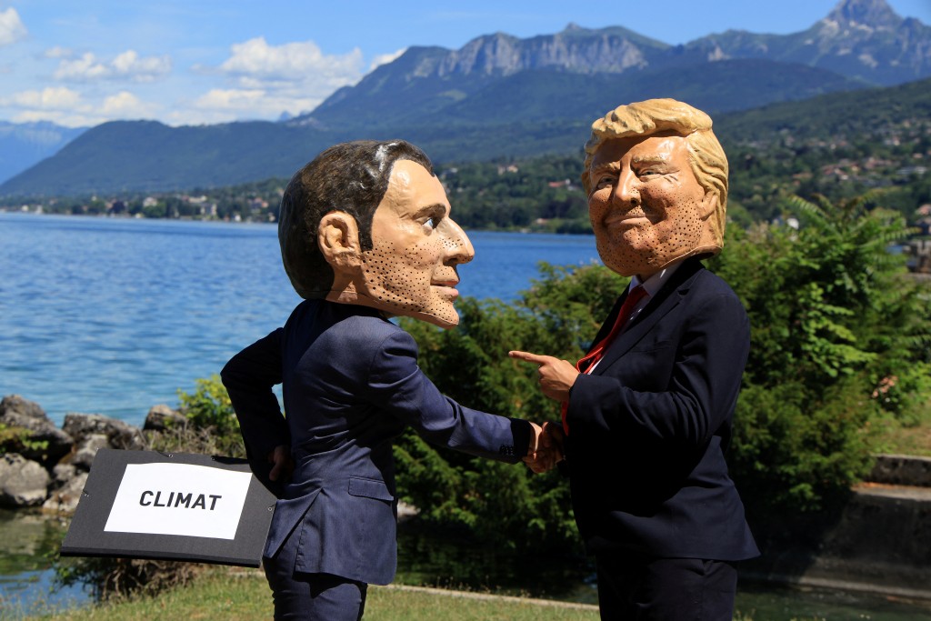 Demonstrators dressed up with caricature "big heads" representing the G7 heads of state France's President Emmanuel Macron and US President Donald Trump, pose during a happening organised by the NGO OXFAM, in Publier, eastern France on June 14, 2026. (AFP)