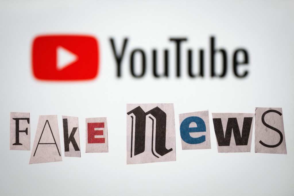An illustration photo shows letters cut out of newspapers arranged to read "Fake news", set up in front of a screen displaying the logo of the US social media, YouTube, in Mulhouse, eastern France, on February 20, 2025.  (Photo by SEBASTIEN BOZON / AFP)