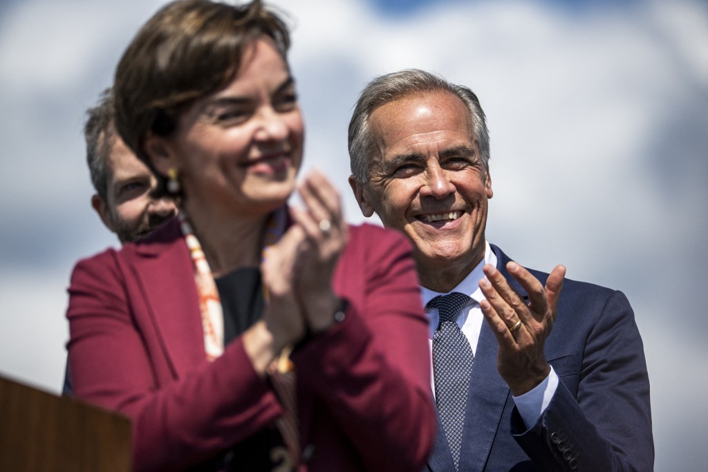 Photo by ANDREJ IVANOV / AFP  Quebec's Prime Minister Christine Frechette (L) applauds during a press conference with Canadian Prime Minister Mark Carney at the Davie Shipyard in Levis, Quebec, Canada on August 24, 2026.