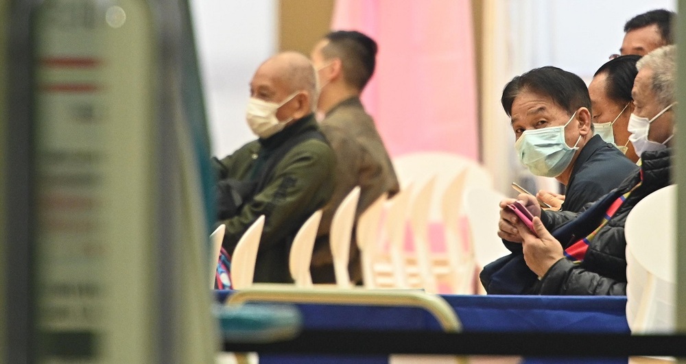 People wait to be inoculated at the Kowloon Bay Sports Centre. People wait to be inoculated at the Kowloon Bay Sports Centre.
