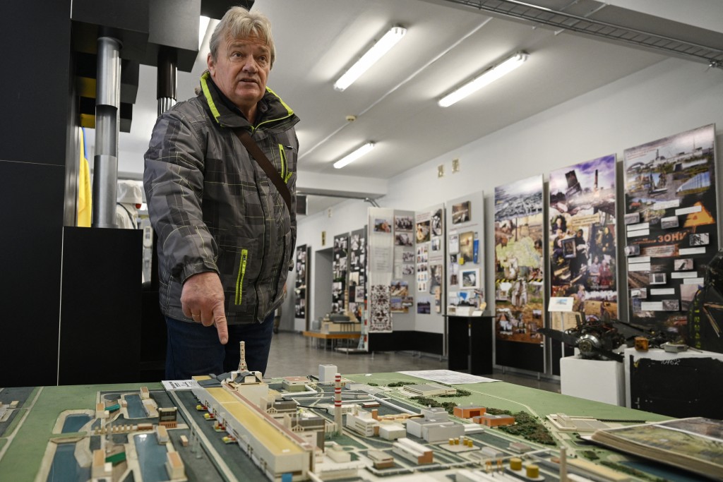 Photo by GENYA SAVILOV / AFP. Nikolay Solovyov, retired Chernobyl Nuclear Power Plant engineer, points to a model of Chernobyl Power Plant as he speaks to AFP journalists in the Museum of the town of Slavutych and the Chernobyl Nuclear Power Plant in Slavutych on April 24, 2026, amid the Russian invasion of Ukraine.