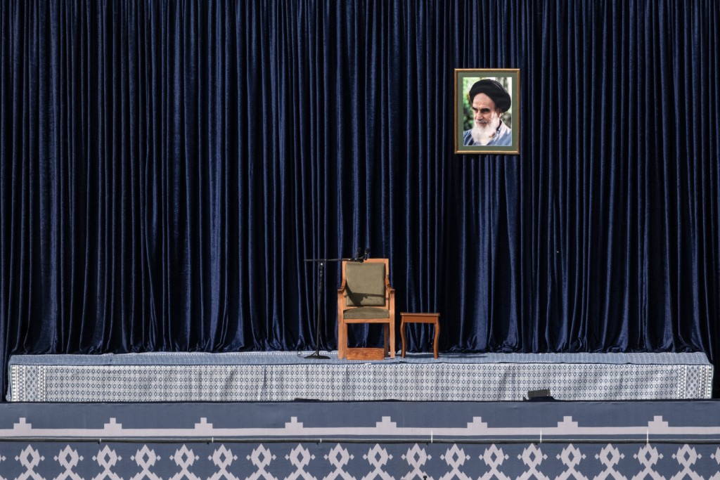 Photo by - / AFP  A portrait of the late founder of the Islamic revolution supreme leader Ayatollah Ruhollah Khomeini is pictured on the podium being used to place the coffins of Iran's slain supreme leader Ayatollah Ali Khamenei and his family members at the Grand Mosalla during the funeral ceremonies in Tehran on July 4, 2026.