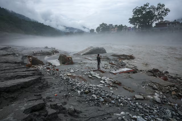 A man takes pictures on a devastated area near the Trishuli River, following the deadly flash floods and a mudslide, in Devighat, Nuwakot district, Nepal, September 4, 2026. REUTERS/Athit Perawongmetha