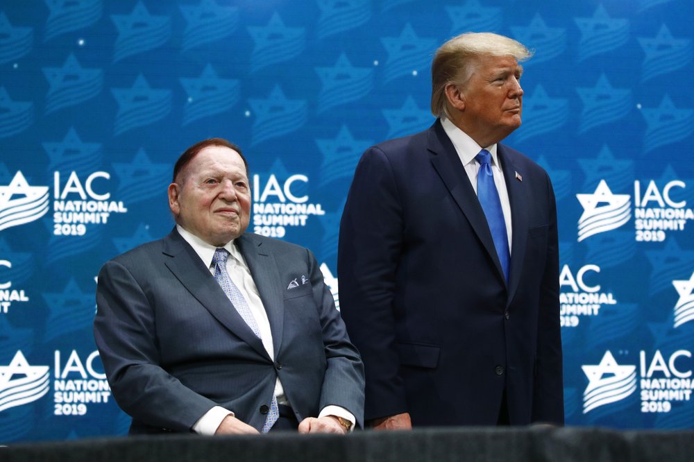 In this December 7, 2019 file photo, President Donald Trump stands alongside Las Vegas Sands Corporation Chief Executive and Republican mega donor Sheldon Adelson before speaking at the Israeli American Council National Summit in Hollywood, Florida. In this December 7, 2019 file photo, President Donald Trump stands alongside Las Vegas Sands Corporation Chief Executive and Republican mega donor Sheldon Adelson before speaking at the Israeli American Council National Summit in Hollywood, Florida.