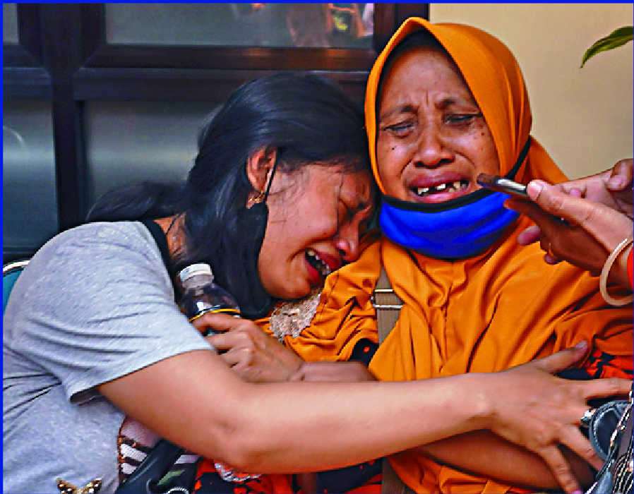 Women cry after a loved one died during the bedlam. AP