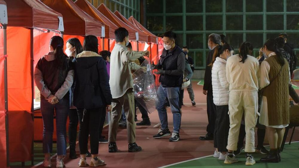 Residents of Fu Yuet House at Fu Cheong Estate undergo compulsory testing as the building is locked down on Wednesday night. 