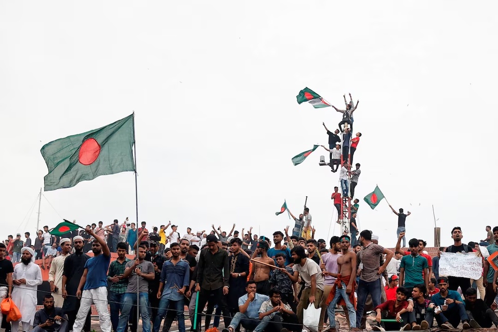 People waves Bangladeshi flags on top the Ganabhaban, the Prime Minister's residence, as they celebrate the resignation of PM Sheikh Hasina in Dhaka, Bangladesh, August 5, 2024. (Reuters) People waves Bangladeshi flags on top the Ganabhaban, the Prime Minister's residence, as they celebrate the resignation of PM Sheikh Hasina in Dhaka, Bangladesh, August 5, 2024. (Reuters)