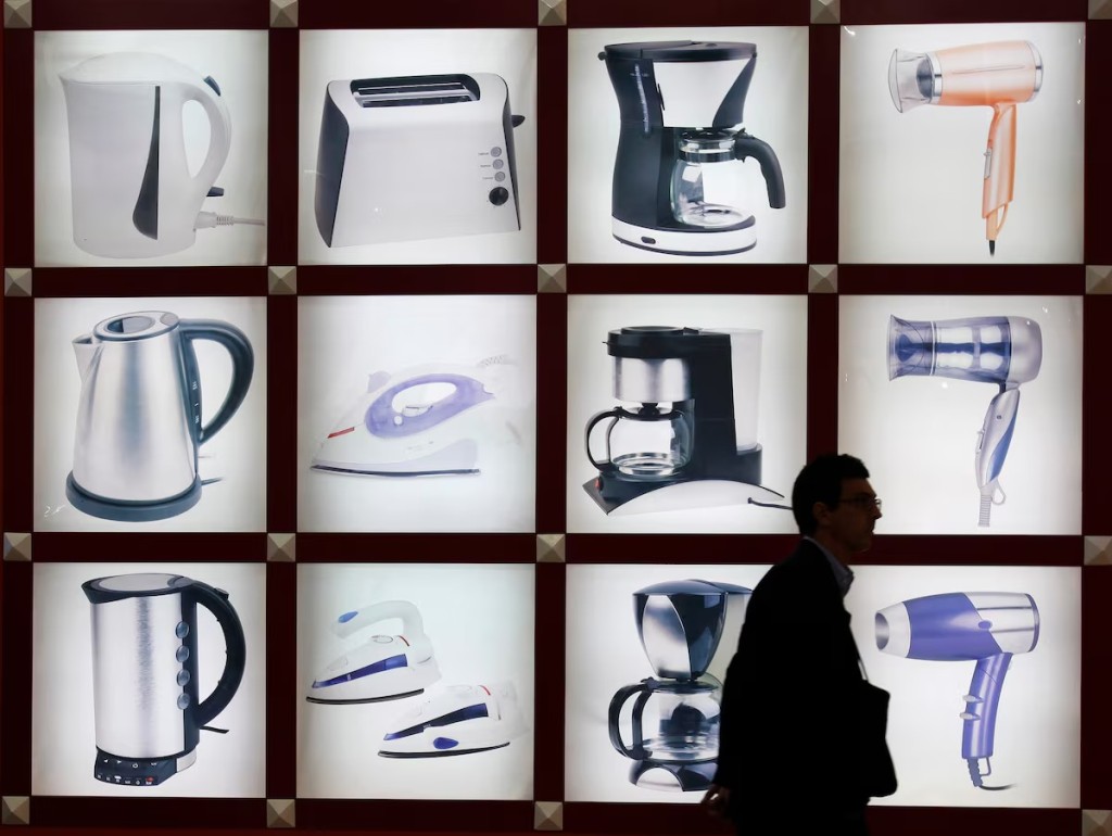A visitor walks past photos of home electrical appliances at China Import and Export Fair, also known as the Canton Fair, in the southern Chinese city of Guangzhou. REUTERS