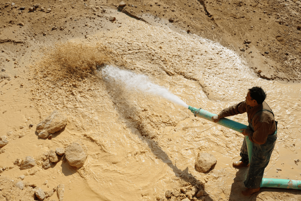 A worker waters the site of a rare earth metals mine at Nancheng county, Jiangxi province January 16, 2011. REUTERS/Stringer (CHINA OUT. NO COMMERCIAL OR EDITORIAL SALES IN CHINA/File Photo