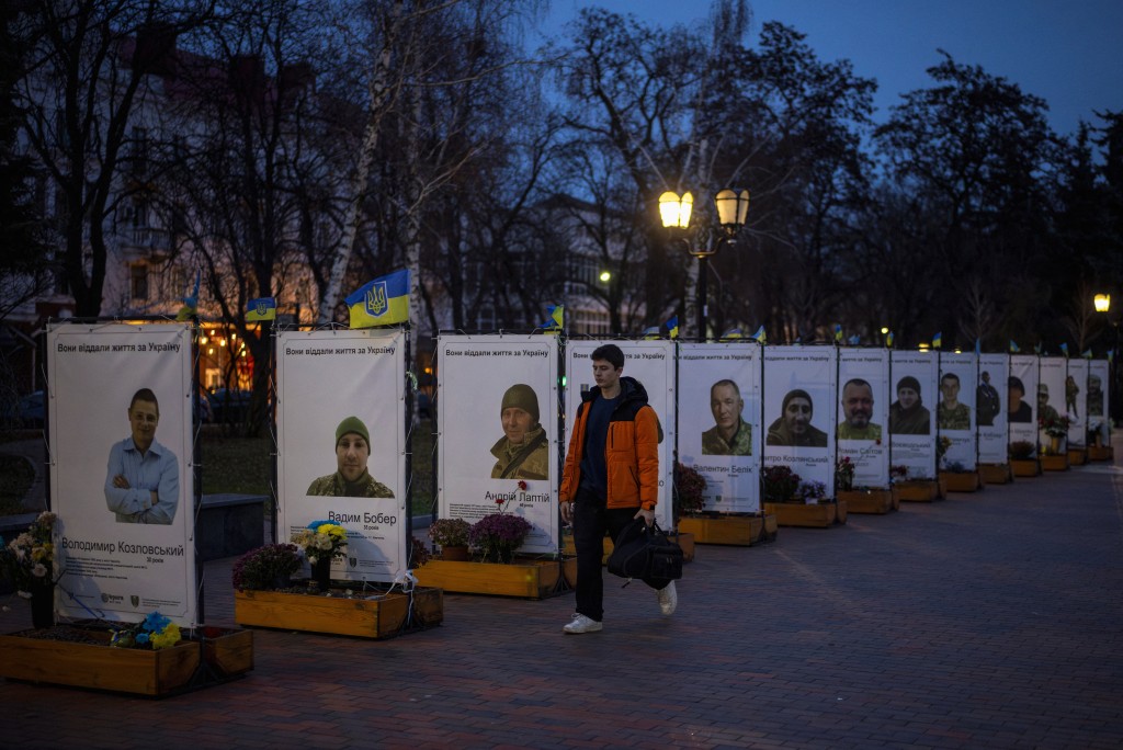 A man walks past portraits of fallen Ukrainian soldiers in Chernihiv, Ukraine, November 25, 2025. REUTERS/Thomas Peter