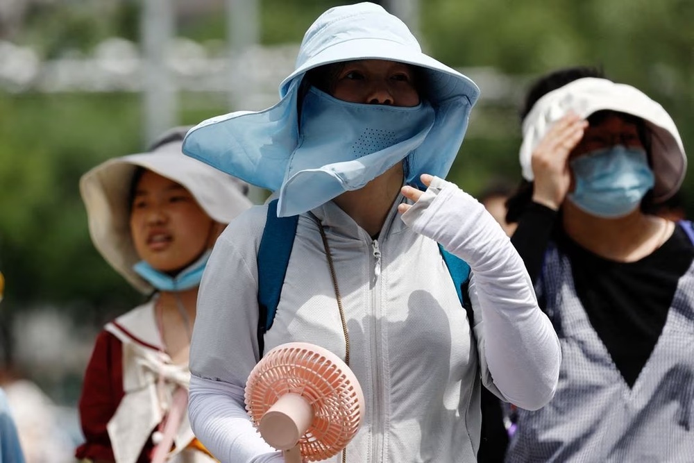 People wearing sun protection gear amid a heatwave walk on a street in Beijing, China July 1, 2023. REUTERS/Tingshu Wang/File Photo People wearing sun protection gear amid a heatwave walk on a street in Beijing, China July 1, 2023. REUTERS/Tingshu Wang/File Photo