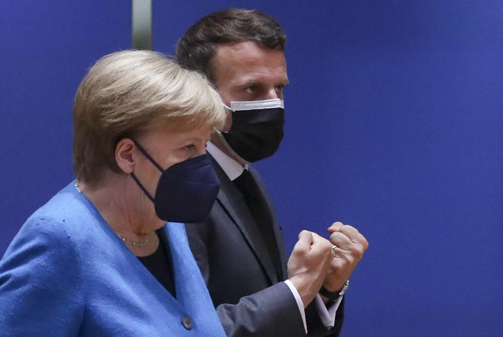 German Chancellor Angela Merkel, left, speaks with French President Emmanuel Macron during a round table meeting at an EU summit in Brussels, Monday, May 24, 2021. German Chancellor Angela Merkel, left, speaks with French President Emmanuel Macron during a round table meeting at an EU summit in Brussels, Monday, May 24, 2021.