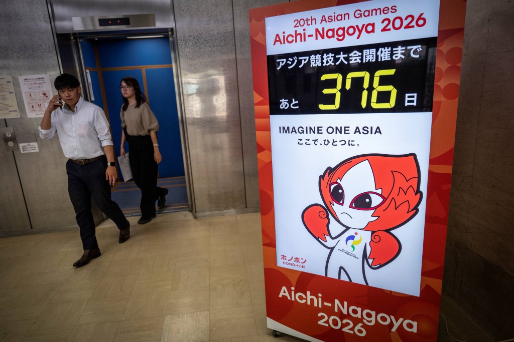 This picture taken on September 8, 2025 shows people walking past a countdown display for the 2026 Aichi-Nagoya Asian Games in Nagoya, Aichi prefecture. (Photo by Yuichi YAMAZAKI / AFP)
