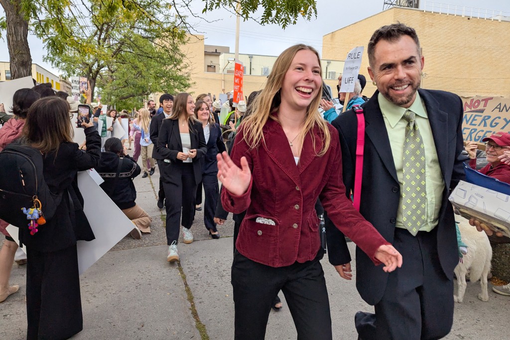 Eva Lighthiser (2R), lead plaintiff in the Lighthiser v. Trump case, walks with attorney Mat dos Santos as they arrive at the Russell Smith Courthouse in Missoula, Montana, on September 16, 2025. (Photo by Issam AHMED / AFP)
