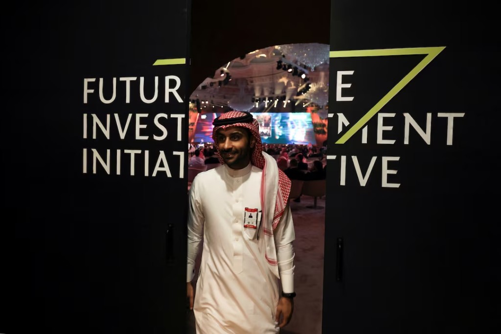 A Saudi man's reflection is seen in mirror glass at the Future Investment Initiative conference, in Riyadh, Saudi Arabia, October 25, 2022. REUTERS/ Ahmed Yosri 