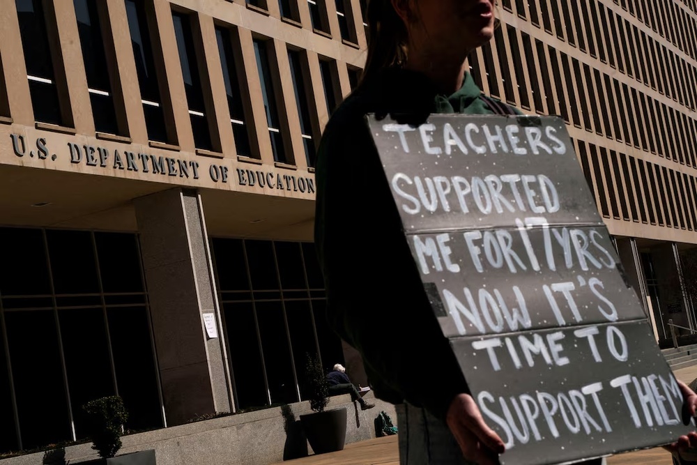 A protester stands near the U.S. Department of Education headquarters after the agency said it would lay off nearly half its staff, in Washington, D.C., U.S., March 12, 2025. REUTERS/Nathan Howard/File Photo A protester stands near the U.S. Department of Education headquarters after the agency said it would lay off nearly half its staff, in Washington, D.C., U.S., March 12, 2025. REUTERS/Nathan Howard/File Photo
