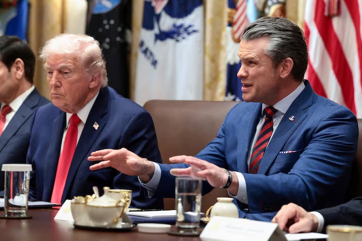 U.S. Defense Secretary Pete Hegseth speaks next to President Donald Trump during a cabinet meeting at the White House in Washington, D.C., U.S., January 29, 2026. REUTERS/Evelyn Hockstein/File Photo