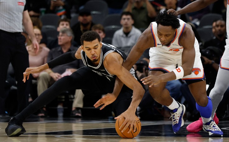 Victor Wembanyama, left, fights for a loose gall with OG Anunoby. AFP 