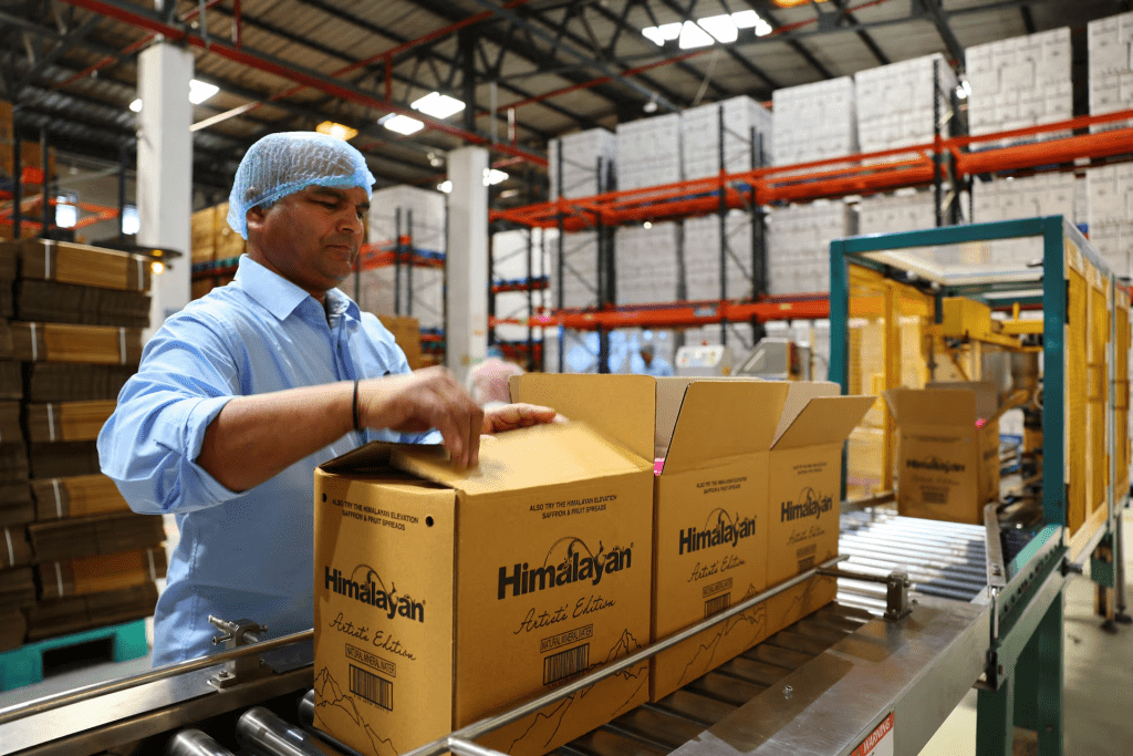 A worker loads PET (Polyethylene Terephthalate) bottles filled with natural water into a cardboard carton at Tata's Himalayan natural mineral water bottling plant in Dhaula Kuan, Himachal Pradesh, India, October 16, 2025. REUTERS/Anushree Fadnavis