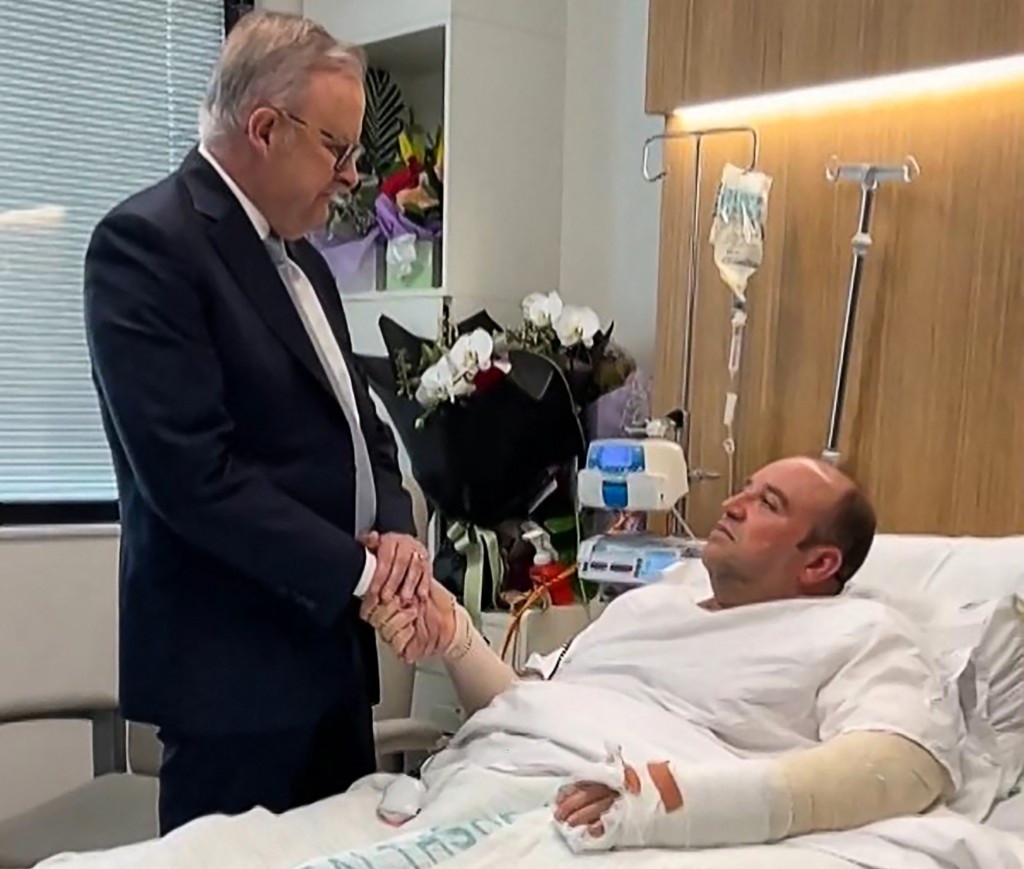 Photo by - / X ACCOUNT OF @ALBOMP / AFP  This frame grab from a video posted on the X (formerly Twitter) account of @AlboMP of Australia's Prime Minister Anthony Albanese taken and released on December 16, 2025 shows Albanese (L) meeting Ahmed al Ahmed, the man who disarmed one of the attackers during the Bondi beach attack, in hospital in Sydney.